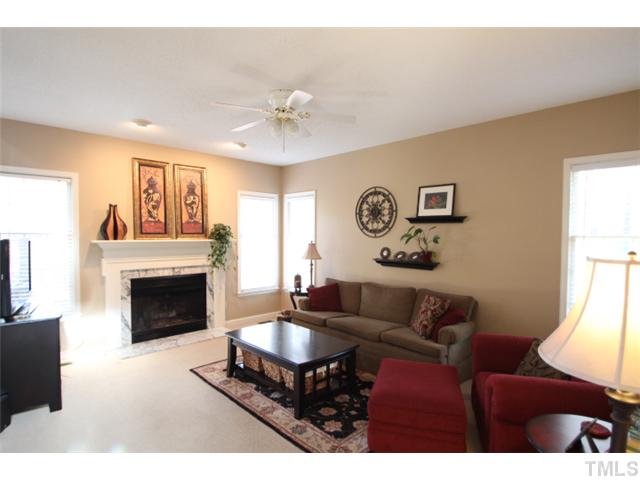 12108 North Exeter Way Raleigh, NC 27613 - Photo 2 of 19 a living room with furniture a fireplace and a flat screen tv