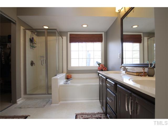 12108 North Exeter Way Raleigh, NC 27613 - Photo 10 of 19 a bathroom with a tub sink shower and a mirror