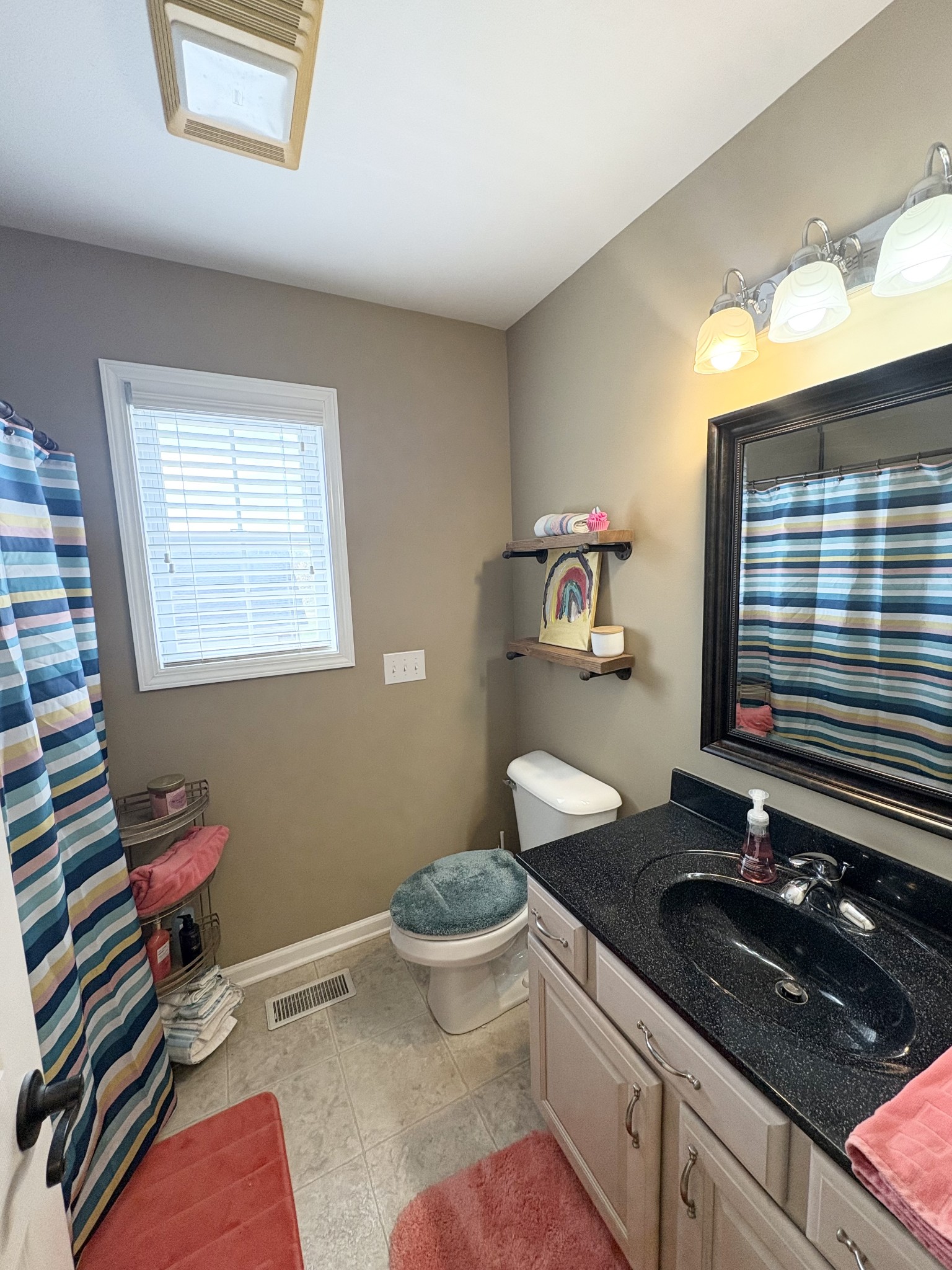 3851 Springdale Road Cunningham, TN 37052 - Photo 16 of 33 a bathroom with a granite countertop toilet a sink and a mirror