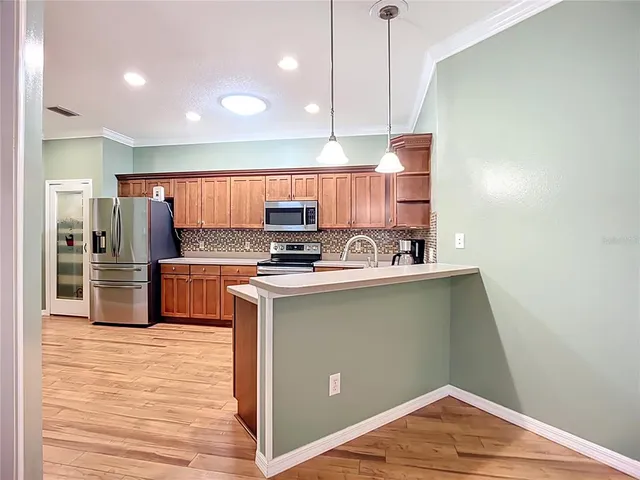 a kitchen with stainless steel appliances a refrigerator and a stove top oven