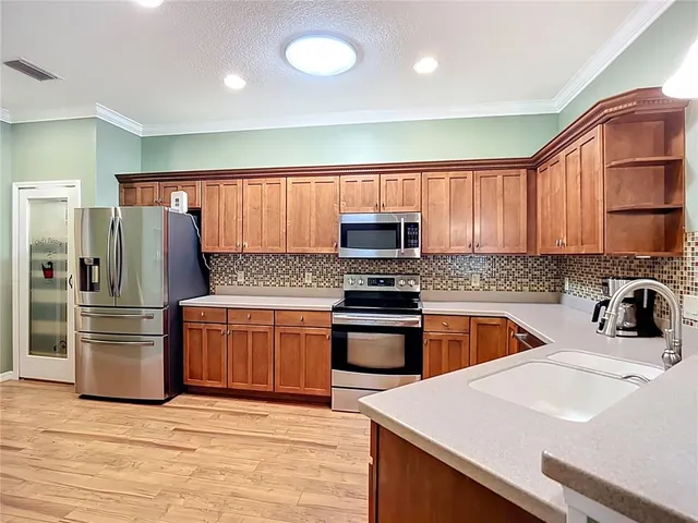 a kitchen with stainless steel appliances granite countertop a refrigerator sink and stove