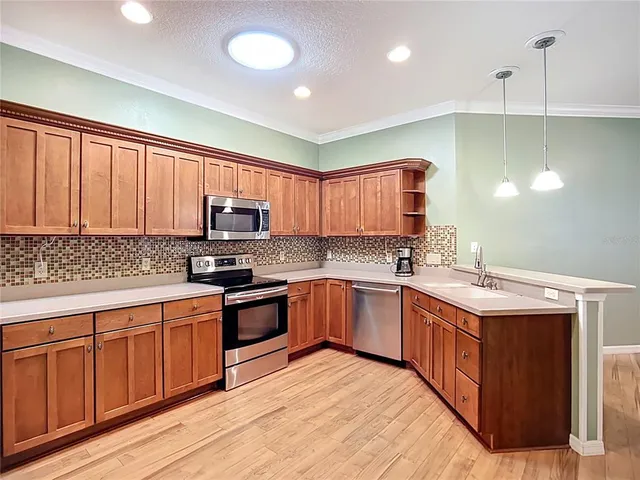 a kitchen with stainless steel appliances granite countertop a stove a sink dishwasher and a refrigerator