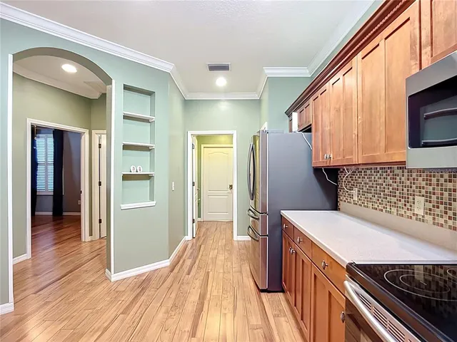 a kitchen with kitchen island wooden floors appliances and cabinets