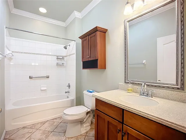 a bathroom with a granite countertop sink a toilet and shower