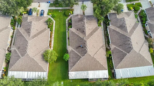 an aerial view of a house with yard and seating space