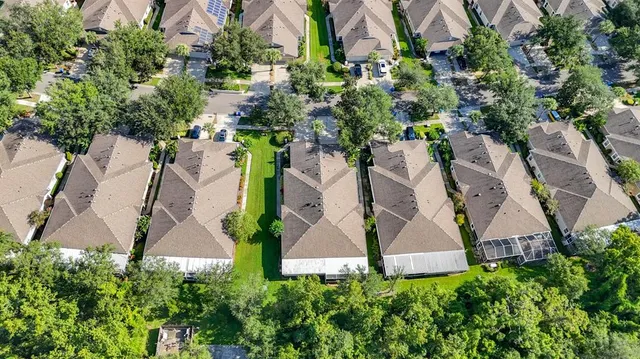 an aerial view of residential houses with outdoor space and swimming pool