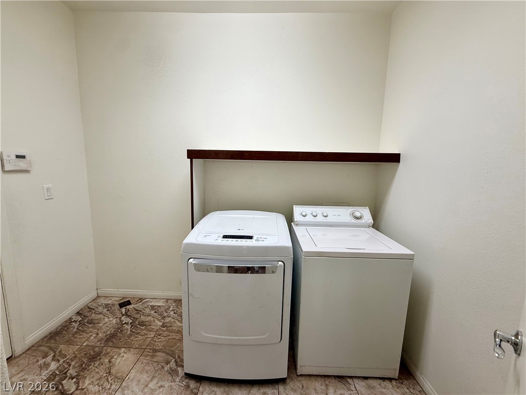 6459 Parrot Ridge Court Las Vegas, NV 89139 - Photo 12 of 23 1st floor. Door to 2 car garage. Functional utility space with durable tile flooring and convenient laundry appliances.