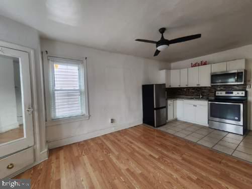 4910 Chestnut Street, Unit 2R Philadelphia, PA 19139 - Photo 2 of 5 a kitchen with stainless steel appliances granite countertop a refrigerator and a stove top oven