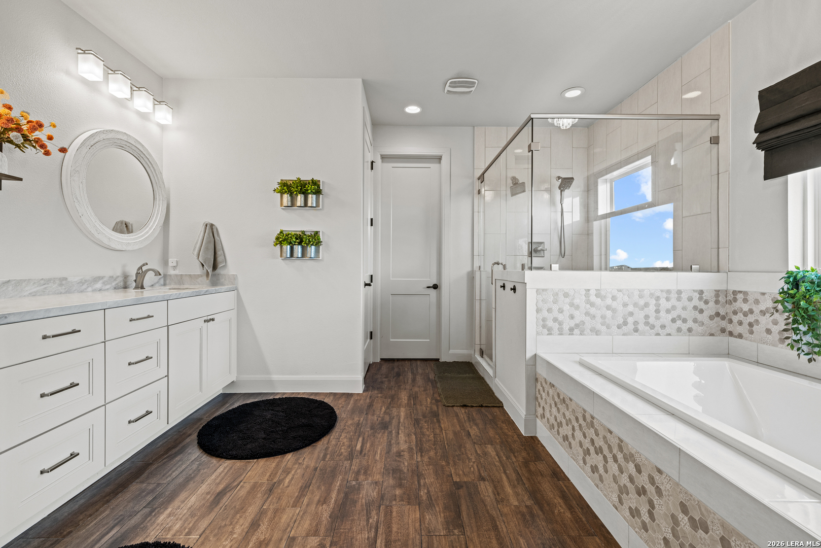 97 Coleman Springs Boerne, TX 78006 - Photo 41 of 86 a bathroom with a granite countertop double vanity sink a mirror a bathtub and shower