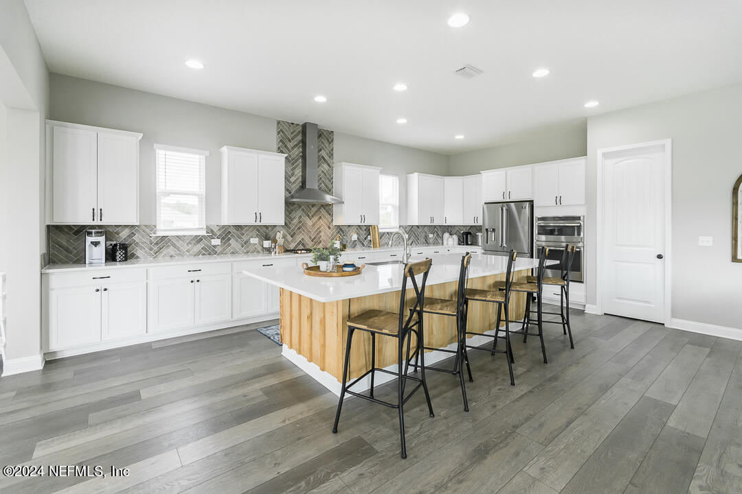 36 Leafmore Lane St. Augustine, FL 32092 - Photo 10 of 38 a kitchen with a dining table chairs wooden floor cabinets and a window