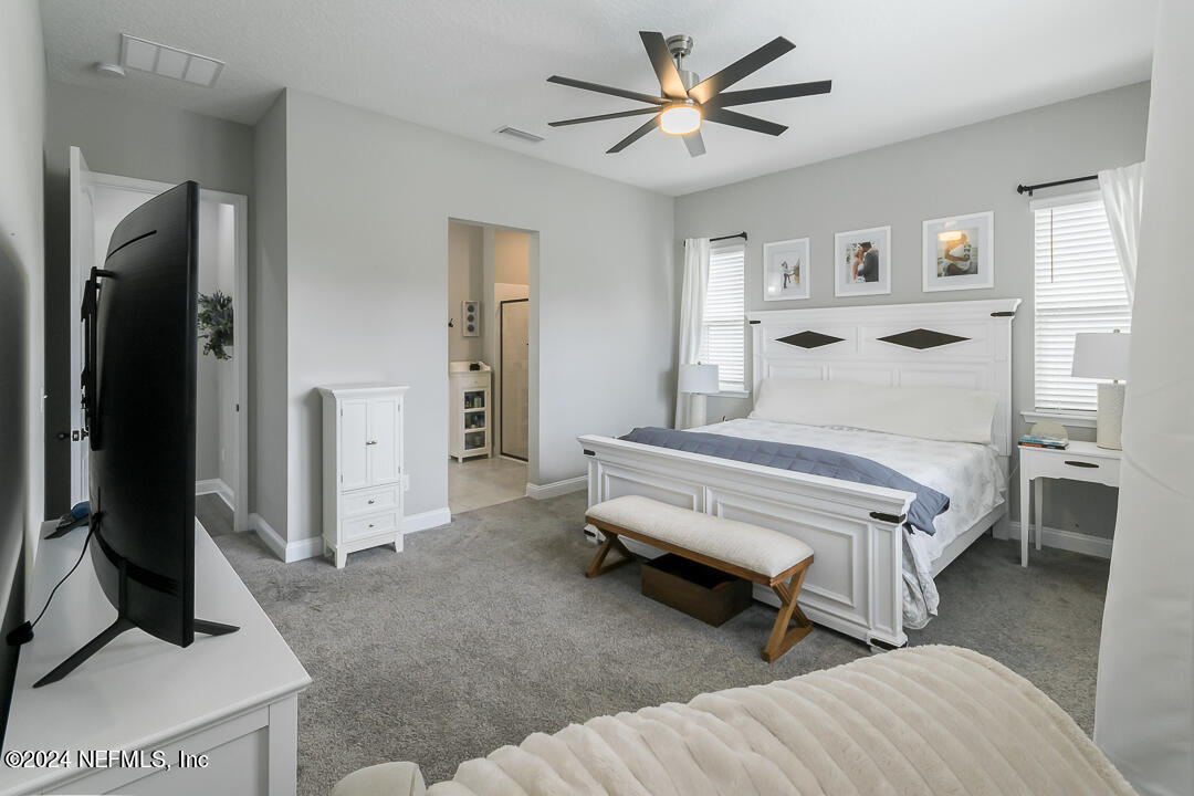 36 Leafmore Lane St. Augustine, FL 32092 - Photo 16 of 38 a bedroom with a bed and a chandelier