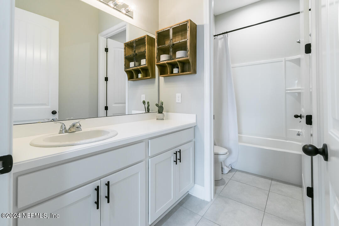36 Leafmore Lane St. Augustine, FL 32092 - Photo 21 of 38 a bathroom with a double vanity sink a mirror a bathtub and shower