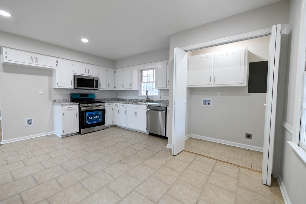 718 Wedron Drive Columbus, GA 31907 - Photo 21 of 38 a kitchen with stainless steel appliances granite countertop a stove top oven a sink and a refrigerator