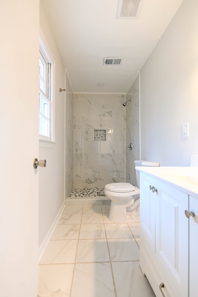 718 Wedron Drive Columbus, GA 31907 - Photo 35 of 38 a bathroom with a granite countertop sink a toilet and a shower