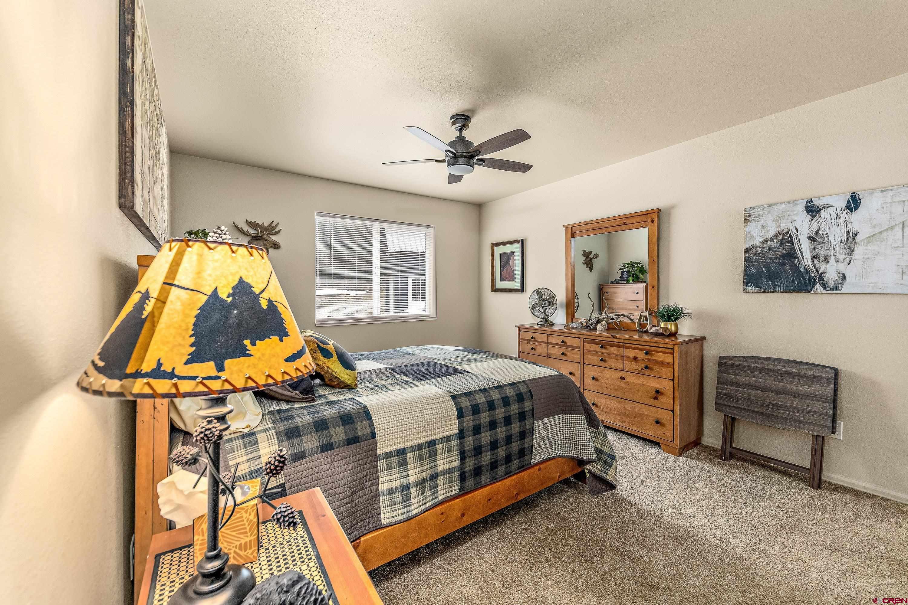 303 Spruce Road Cimarron, CO 81220 - Photo 14 of 35 a bedroom with a bed and a chandelier