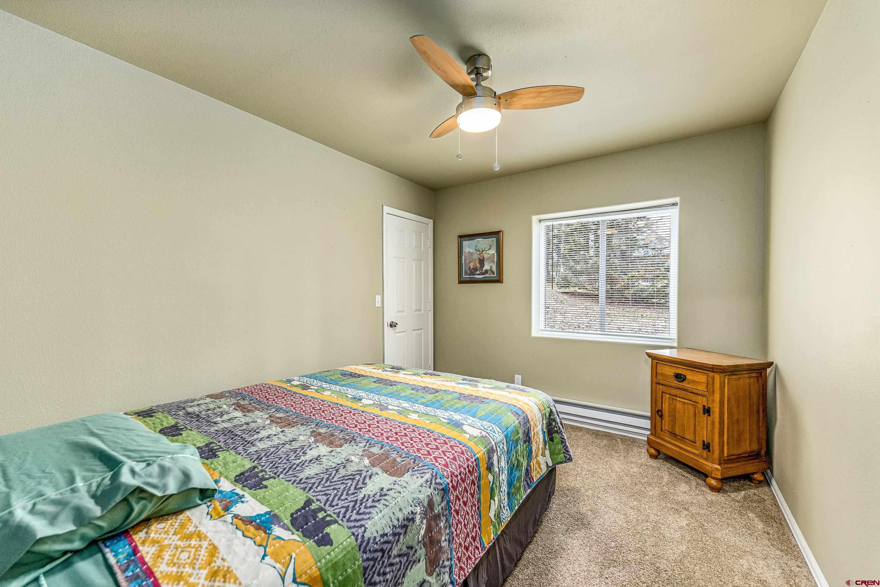 303 Spruce Road Cimarron, CO 81220 - Photo 17 of 35 a bedroom with a bed and a tv