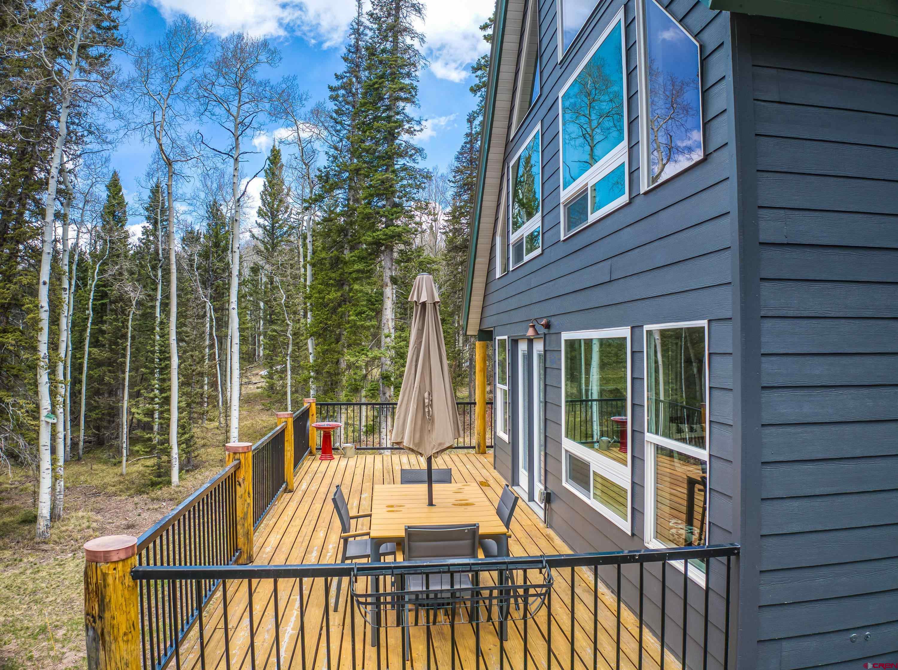 303 Spruce Road Cimarron, CO 81220 - Photo 8 of 35 a view of roof deck with large windows and wooden floor