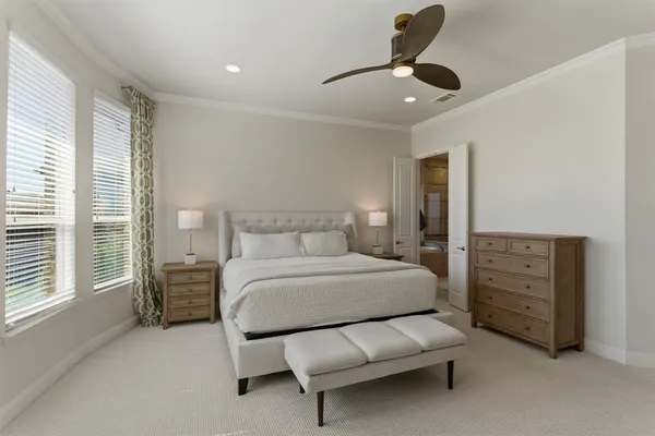 a spacious bedroom with a bed couch and window