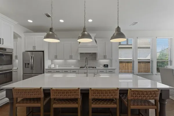 a kitchen with stainless steel appliances granite countertop a kitchen island a stove and a cabinets