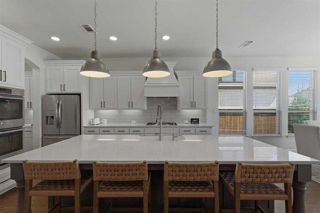 2801 Seabiscuit Road Celina, TX 75009 - Photo 7 of 39 a kitchen with stainless steel appliances granite countertop a kitchen island a stove and a cabinets