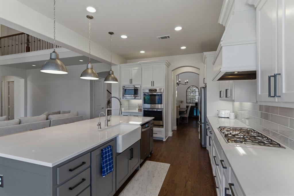 2801 Seabiscuit Road Celina, TX 75009 - Photo 9 of 39 a large white kitchen with stainless steel appliances granite countertop a sink and cabinets