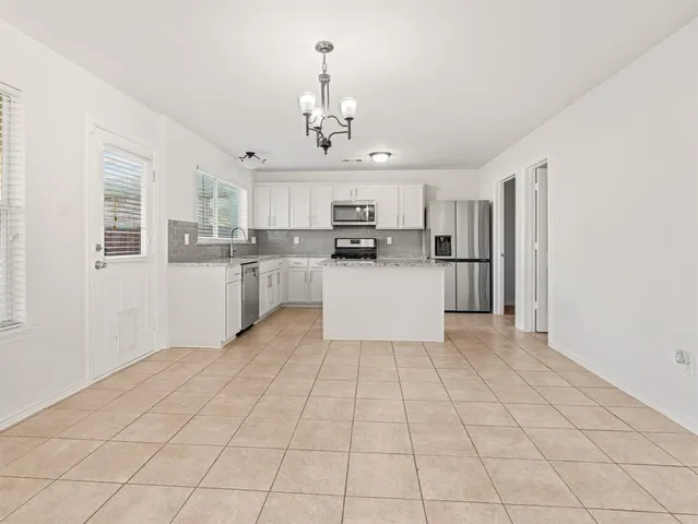 a large white kitchen with cabinets