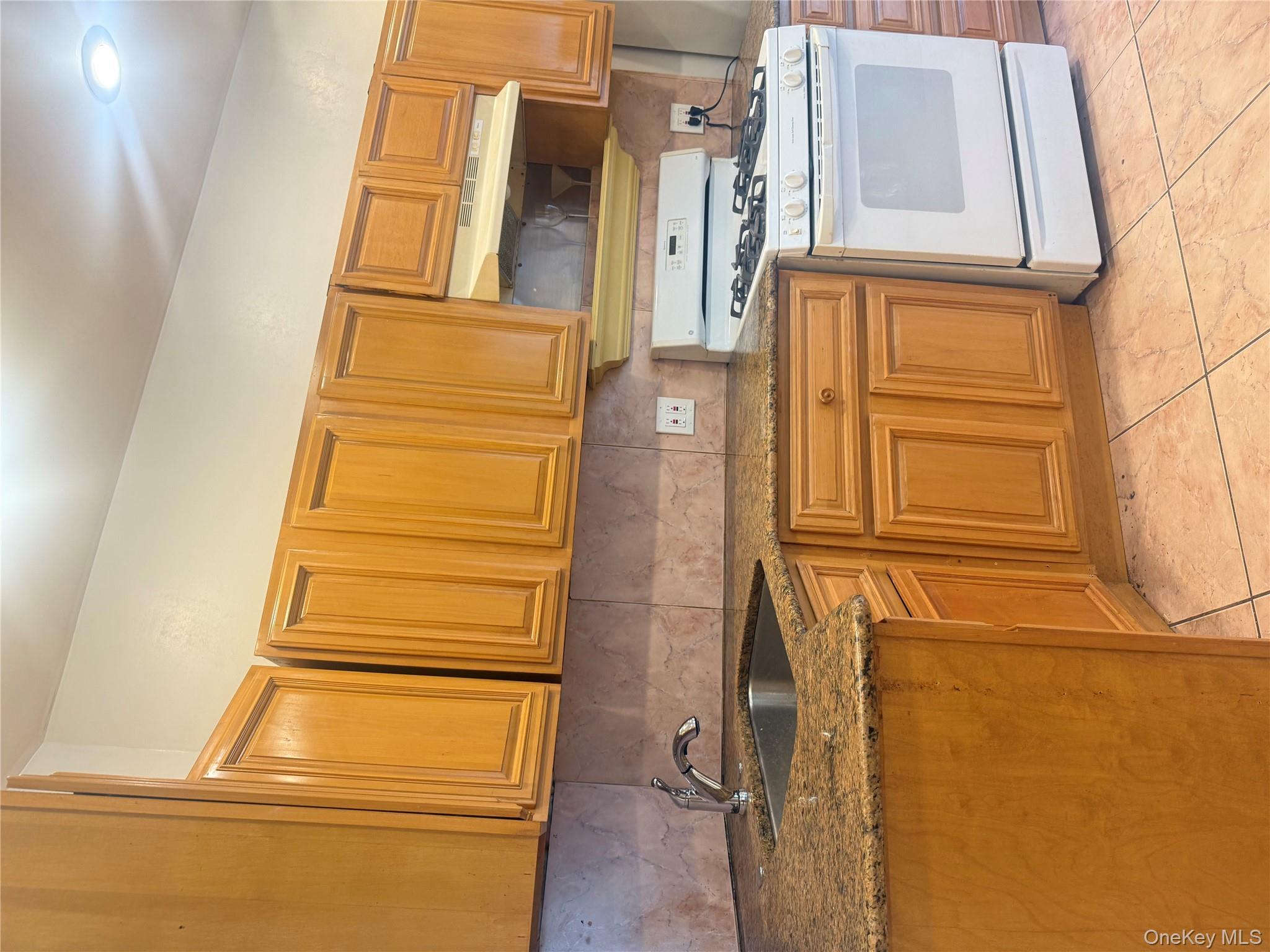 68-13 60th Street Queens, NY 11385 - Photo 11 of 27 a kitchen with stainless steel appliances granite countertop a sink stove and cabinets