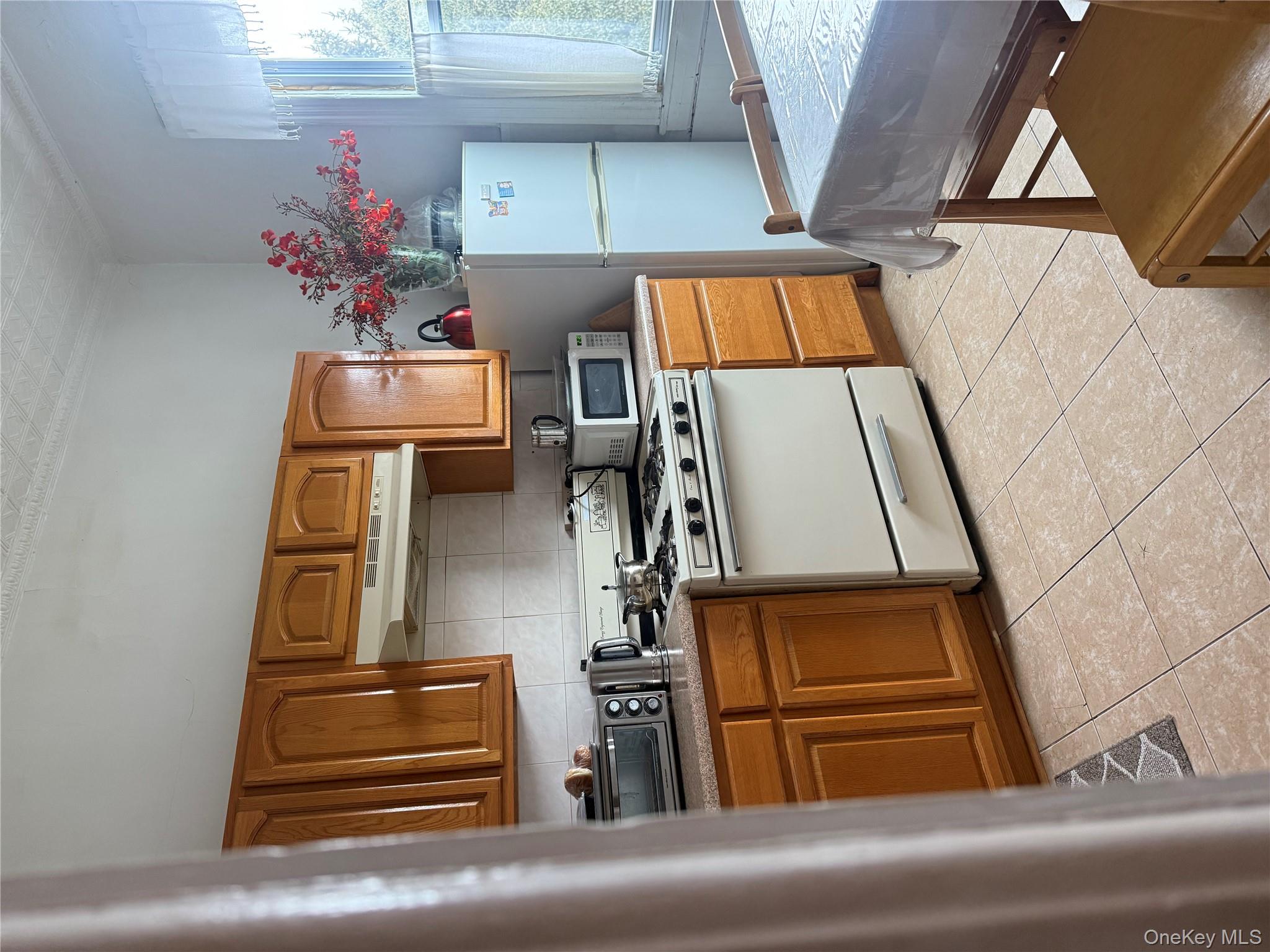 68-13 60th Street Queens, NY 11385 - Photo 17 of 27 a kitchen with stainless steel appliances granite countertop a sink stove and refrigerator