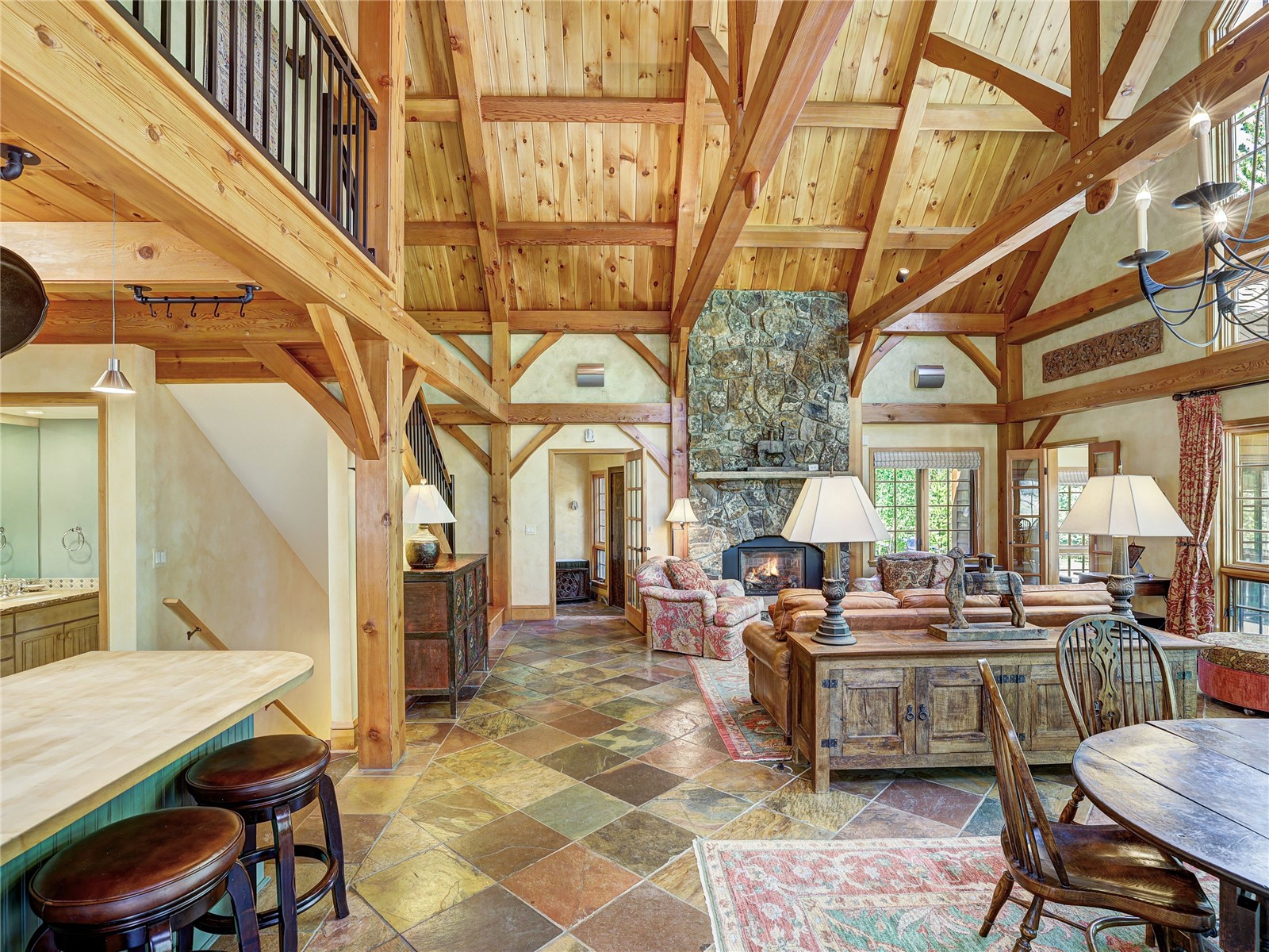 840 Penstemon Road Keystone, CO 80435 - Photo 14 of 50 Living room with stone tile flooring, high vaulted ceiling, a wood ceiling with exposed beams, and a fireplace