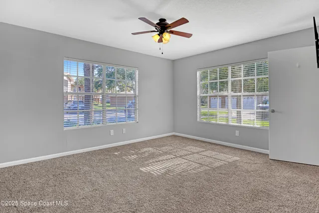 a view of a livingroom with a ceiling fan and window