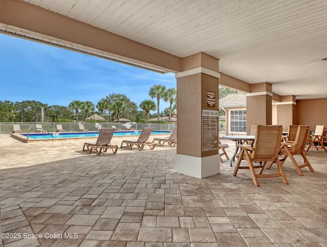 a view of a patio with a table and chairs and potted plants