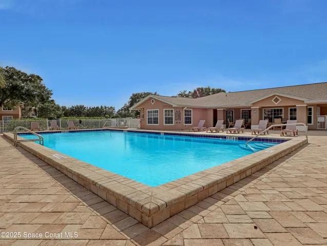 a view of a house with pool and chairs