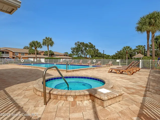 a swimming pool with outdoor seating and yard in the back
