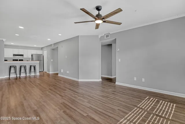 a view of a livingroom with a kitchen counter tops and wooden floor