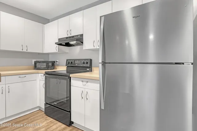 a kitchen with stainless steel appliances a refrigerator and cabinets
