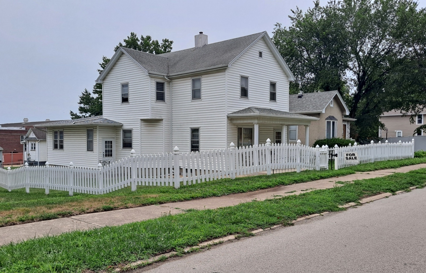 a front view of a house with a yard and table and garage
