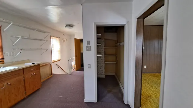 a view of a hallway with wooden shelves