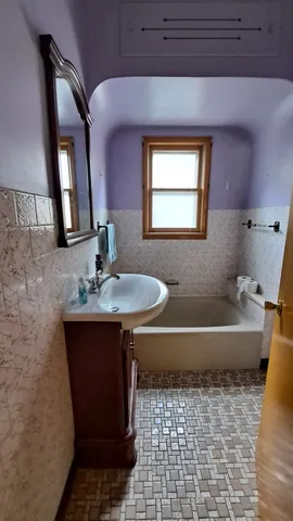 a bathroom with a sink a bathtub and a mirror