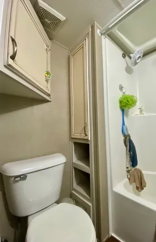 a bathroom with a toilet a sink and shower