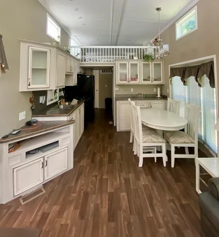 a kitchen with stainless steel appliances a dining table chairs and granite counter tops