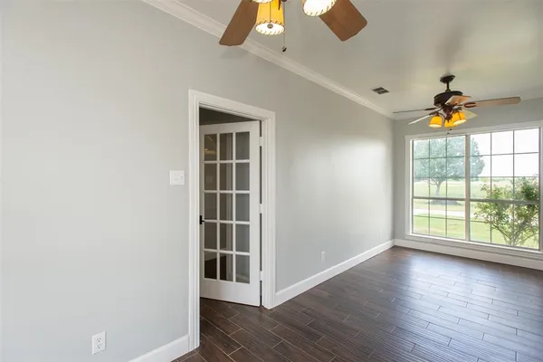 an empty room with wooden floor and windows