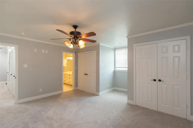 a view of an empty room and a chandelier fan