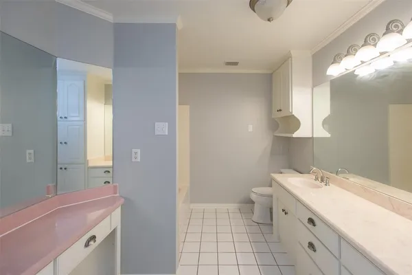 a bathroom with a double vanity sink a toilet and a mirror