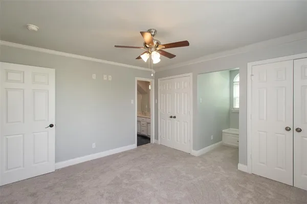 a view of an empty room and a ceiling fan window