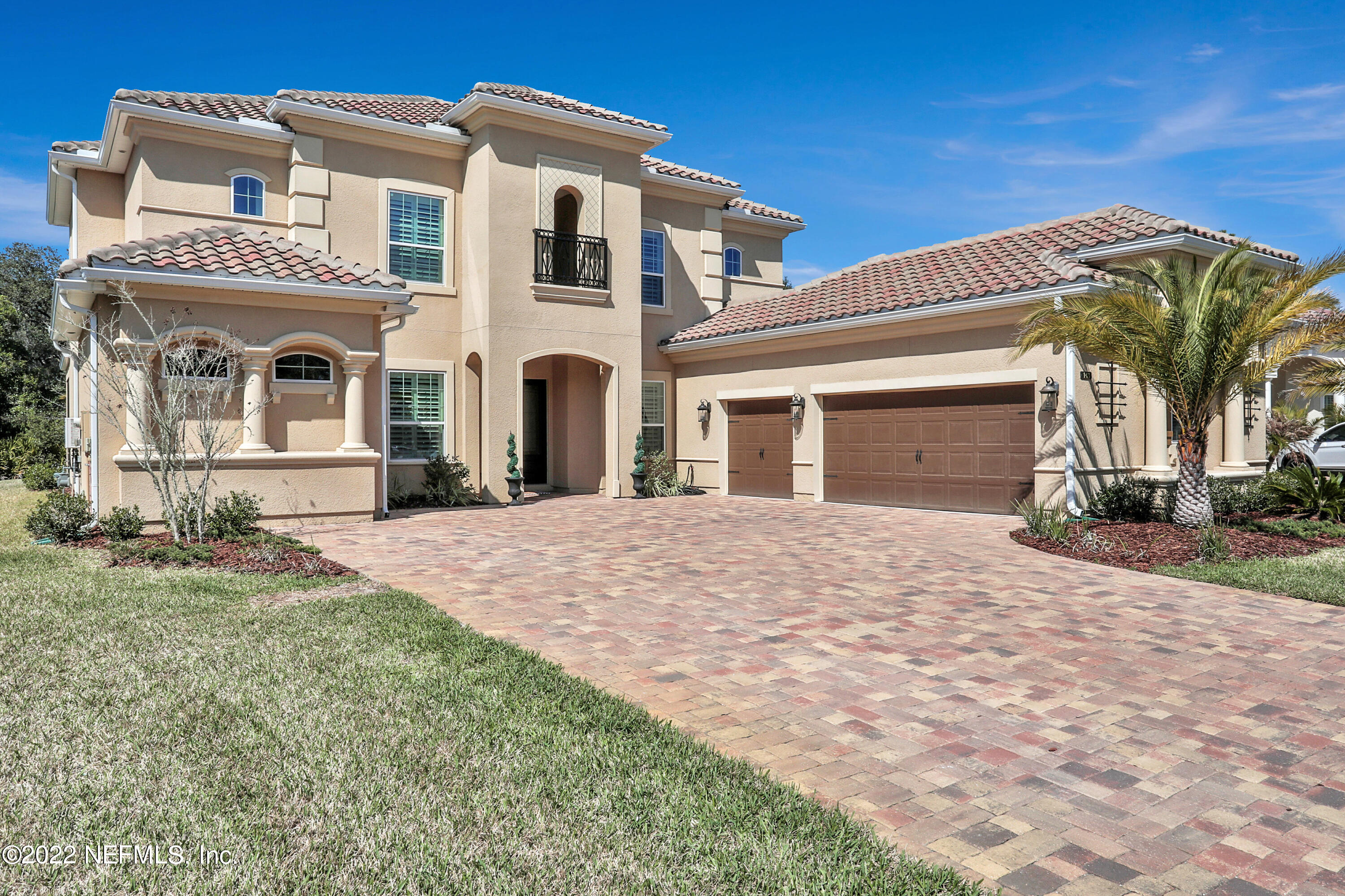 a front view of a house with yard and trees