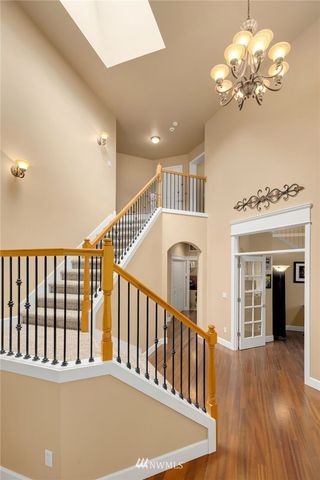 a view of staircase with railing and a chandelier