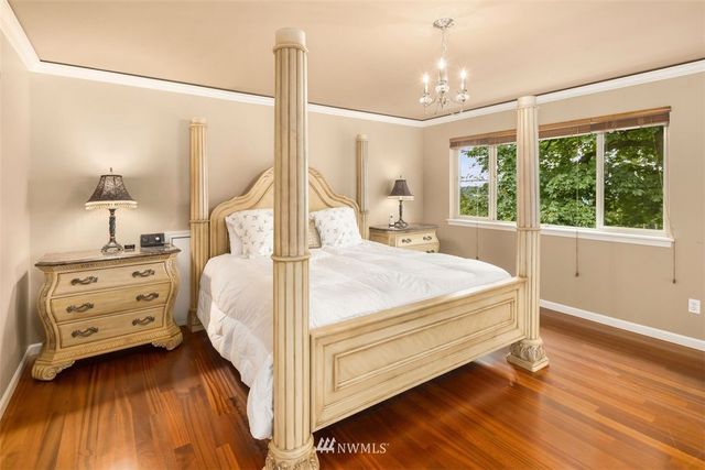 a bedroom with a bed and large windows
