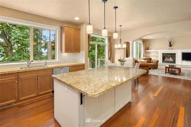 a kitchen with a stove a sink and living room view