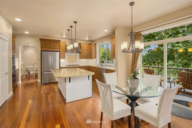 a view of a dining room and livingroom with furniture wooden floor a chandelier