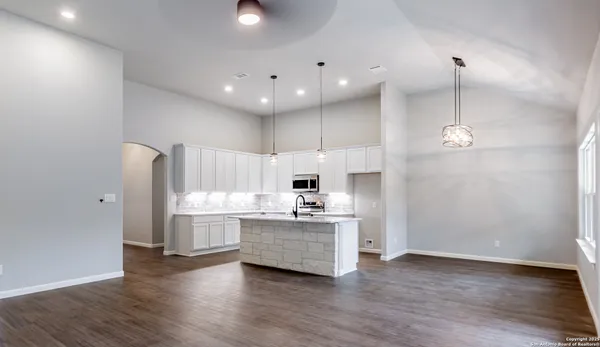 a kitchen with kitchen island a sink and a stove top oven